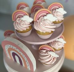 cupcakes with pink icing and white frosting are on a cake stand