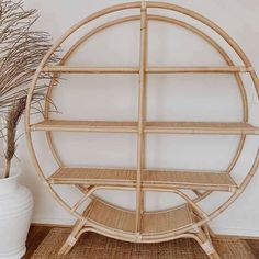 a bamboo shelf sitting on top of a rug next to a potted plant