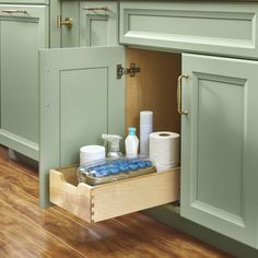 an open drawer in a kitchen filled with toilet paper and other items on the counter