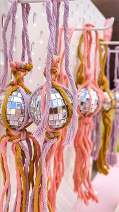 several disco balls hanging from a rack with tassels