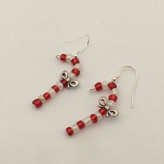 Fun Christmas earrings, beaded candy cane design dangle earrings.  Created with red and white glass seed beads and featuring a a pewter bow.  The canes hang from a sterling silver ear wire.  A great idea for Christmas stocking fillers. The cute earrings drop 4cm in length. They are available to be shipped immediately and will arrive packaged in a kraft paper pillow box ready to give as a gift or as a gift for yourself! Diy Christmas Earrings Beads, Candy Cane Beaded Earrings, Christmas Earrings Beads, Christmas Jewelry Aesthetic, Christmas Seed Bead Jewelry, Earings Beads Ideas, Beaded Earrings Christmas, Christmas Diy Earrings, Cute Christmas Earrings