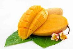 two pieces of mango sitting on top of a green leaf