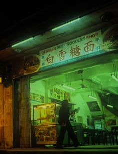 a man walking past a store front at night