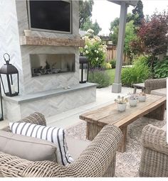 a patio with wicker furniture and a fireplace