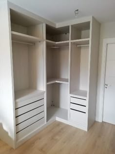 an empty room with white shelves and drawers