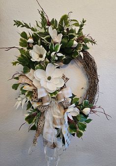 a wreath with white flowers and green leaves