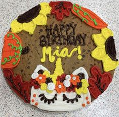 a decorated birthday cake with the words happy birthday mia on it's face and decorations