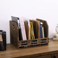 a wooden desk with some books and pencils in it on top of a table