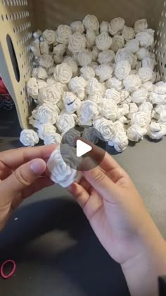 someone is making white roses out of paper machs with scissors in front of them