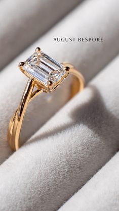 a gold ring with an emerald cut diamond