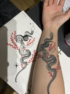 a woman's arm with a tattoo on it that has a snake on it