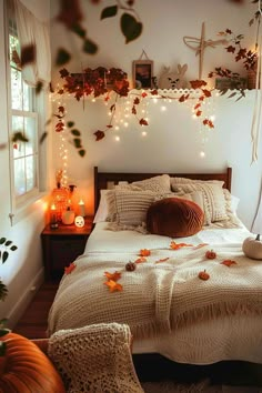 a bedroom decorated with fall leaves and candles on the bed, along with other decorations