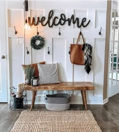 a wooden bench sitting in front of a welcome sign on a white wall next to a basket