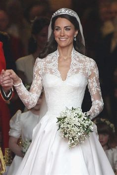 the bride and groom are holding hands as they walk down the aisle at their wedding