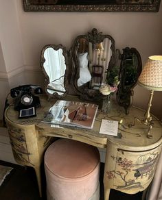 an antique vanity with mirror, stool and lamp