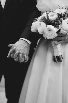 the bride and groom are holding hands