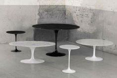 three tables and two stools in an empty room