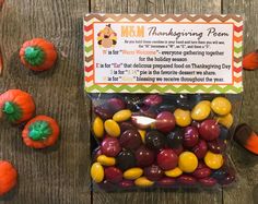 a bag filled with lots of candy sitting on top of a wooden table next to small pumpkins