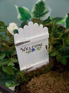 a welcome sign sitting on top of a potted plant