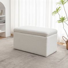 a white storage bench sitting on top of a carpeted floor next to a window