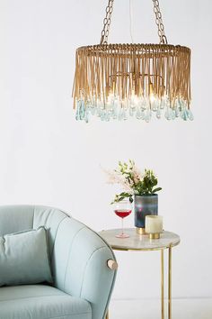 a living room with a blue chair and a table that has a wine glass on it