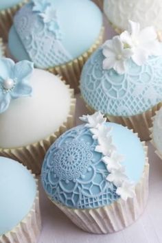 several blue and white cupcakes with flowers on them are arranged in a pattern