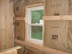 an unfinished room with wooden walls and windows in the process of remodeling