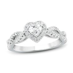 a heart shaped diamond ring with diamonds on the band and an intertwined band around it