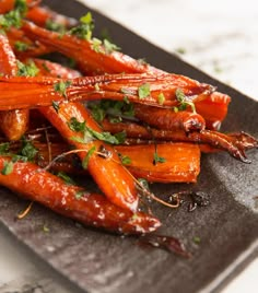 carrots with parsley and herbs on a black plate