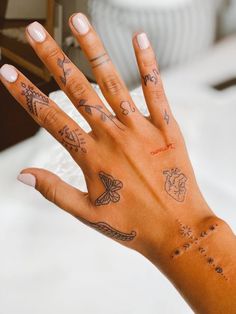 a woman's hand with many tattoos on it