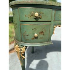 an old green dresser with gold trim and knobs on it's drawers is shown