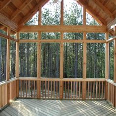 the inside of a wooden building with lots of windows and wood flooring on it