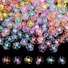 many different colored plastic beads on a black background with one bead in the middle