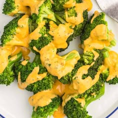 broccoli florets covered in yellow sauce on a plate with a fork