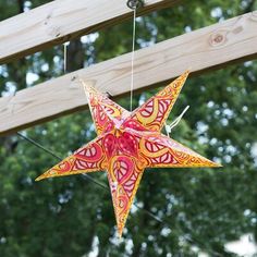 an origami star hanging from a wooden structure