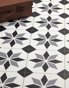 a suitcase sitting next to a black and white floor with star designs on it's sides