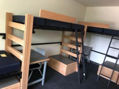 there are bunk beds and desks in this room