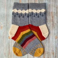 two pairs of colorful socks sitting on top of a wooden floor