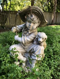 a statue of a boy holding a sheep in the grass