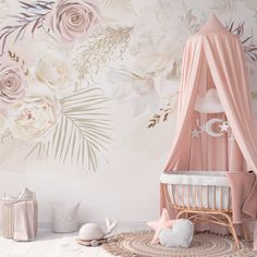 a baby's room decorated in pink and white with flowers on the wall behind it