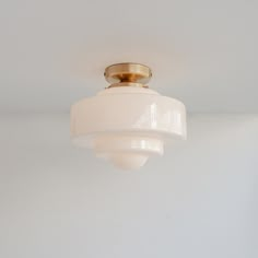 a white ceiling light hanging from the ceiling in a room with no one around it