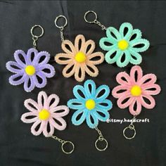 four crocheted flower key chains on a black background with the words, granny's daisy