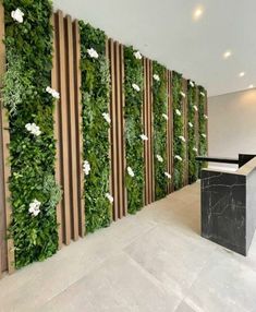 an office lobby with green walls and marble counter tops, white flowers on the wall