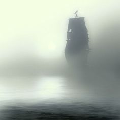 an old ship in the middle of foggy water