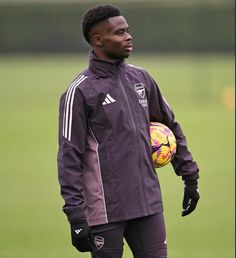 a man holding a soccer ball on top of a field