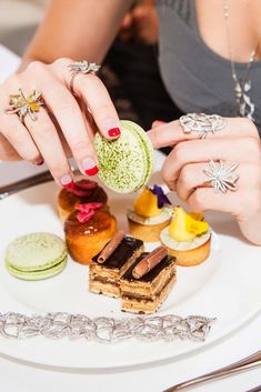 a woman is holding onto a plate with desserts on it