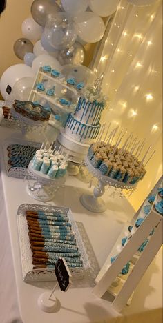 a table topped with lots of blue and white desserts