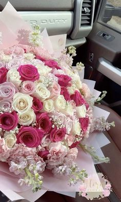 a bouquet of pink and white flowers sitting in the back seat of a car