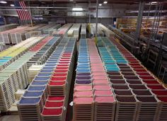 several rows of boxes filled with different colored powders in a large warehouse or factory