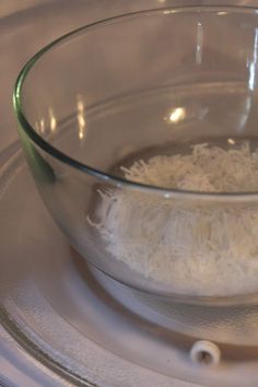 a glass bowl filled with rice on top of a stove